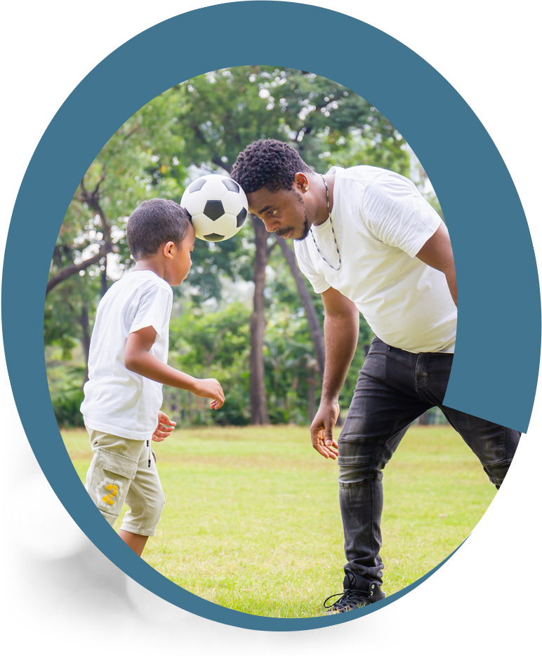 Father and young son playing soccer